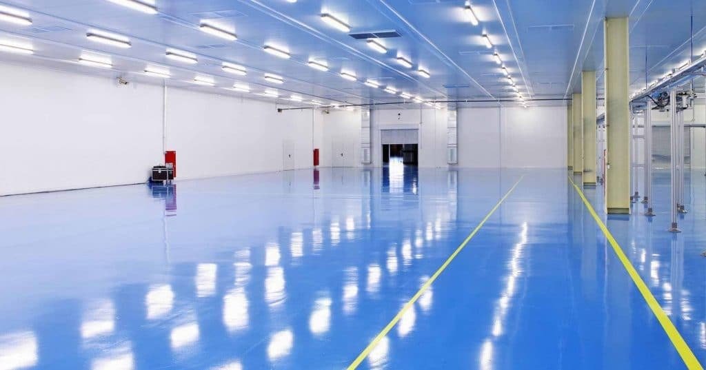 Glossy blue epoxy flooring installed in a warehouse