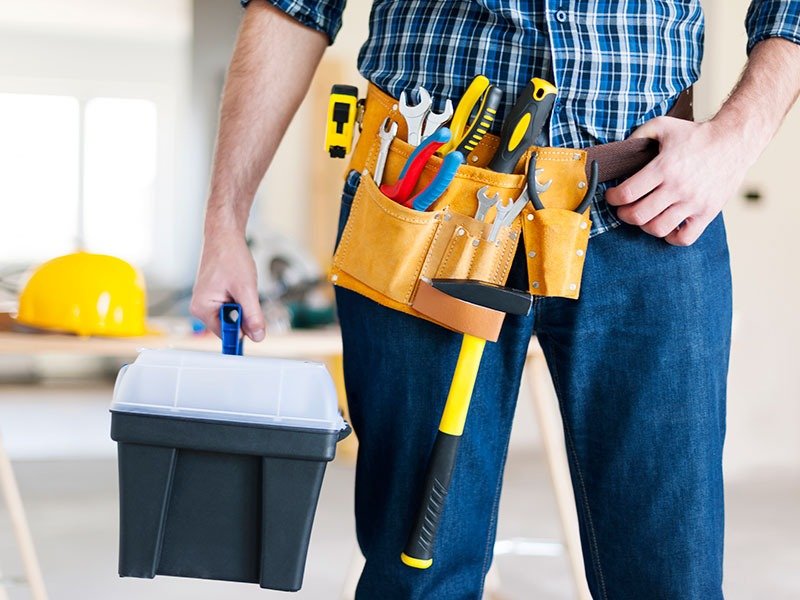 Maintenance technician with tool belt and toolbox